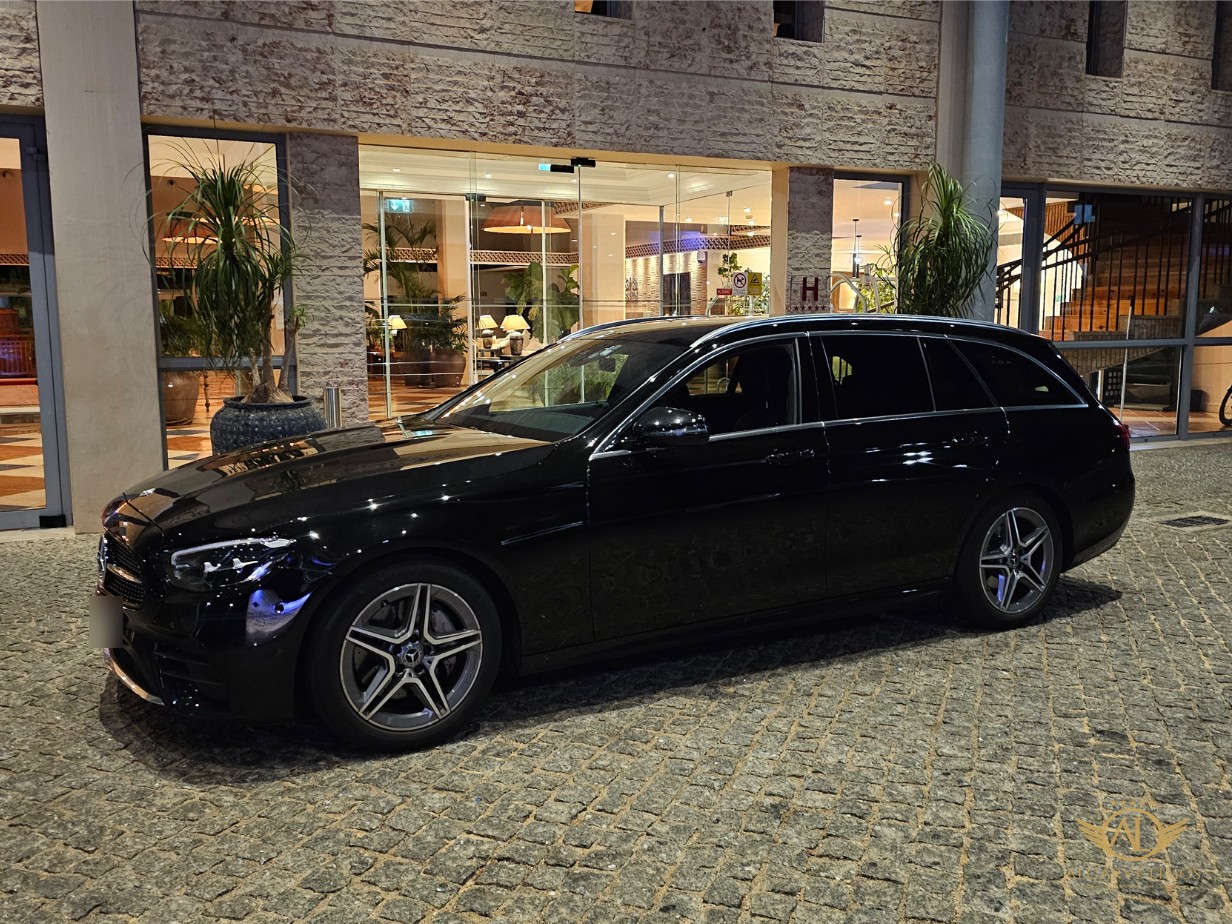 Algarve Limos Mercedes-Benz E-Class estate at a hotel entrance at night